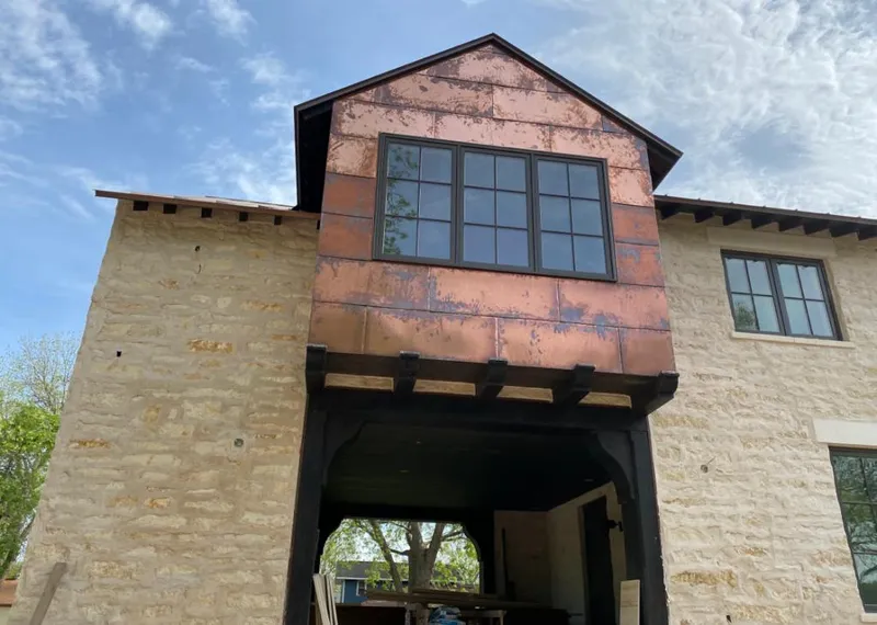 Copper metal panel facade on a stone building for Roof Repair in Watauga