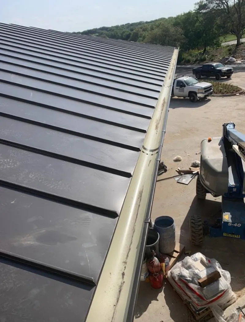 Standing seam panel and gutter detail on a metal roofing jobsite in Watauga